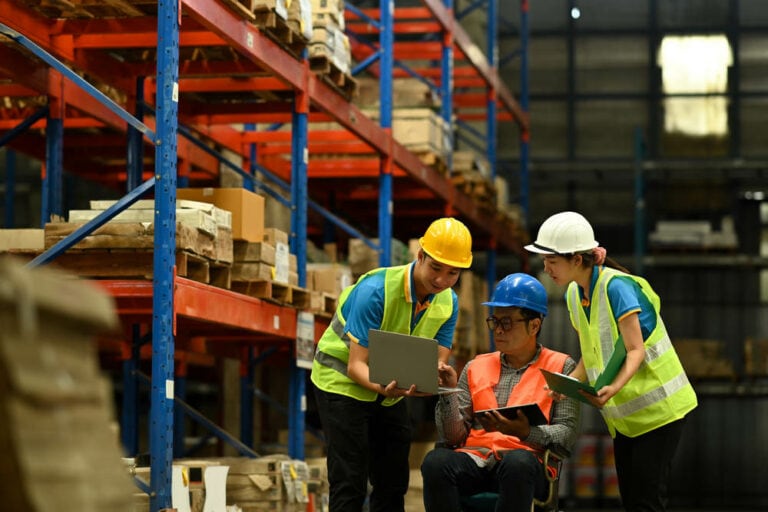 Arbeiter verwenden Laptop, um den Bestand zu überprüfen